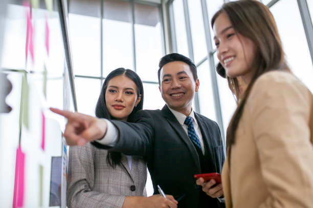 亚洲商务团队的男女同事在工作中交谈，分享想法与图表在板上，快乐年轻的演示同事一起工作在板上。图片下载