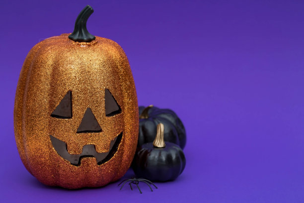 万圣节派对的现代明信片。南瓜杰克，黑色的南瓜，时髦的紫色背景。带有文本复制空间的横幅。图片下载