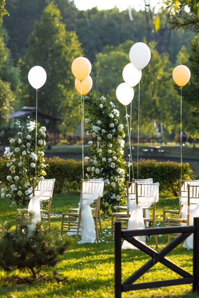 美丽的婚礼装饰。举行婚礼仪式的地方花的拱门，用织物装饰的金色椅子，球。时尚的装饰。插花是节日装饰的一部分。图片下载