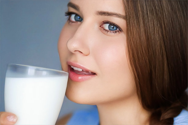 快乐的年轻女子与一杯牛奶或蛋白质鸡尾酒，健康的饮料，饮食和健康图片下载