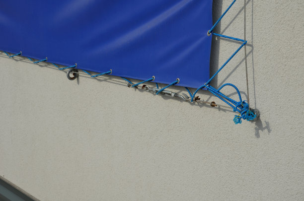 广告防水布通过电缆安装在房屋外立面的金属镀锌眼内。移动广告解决方案，在公寓建筑的户外使用容易更换的内容图片下载