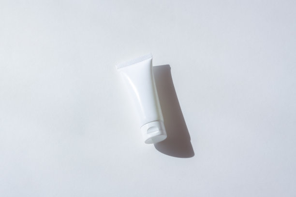 化妆瓶与阴影在白色的墙壁背景图片下载