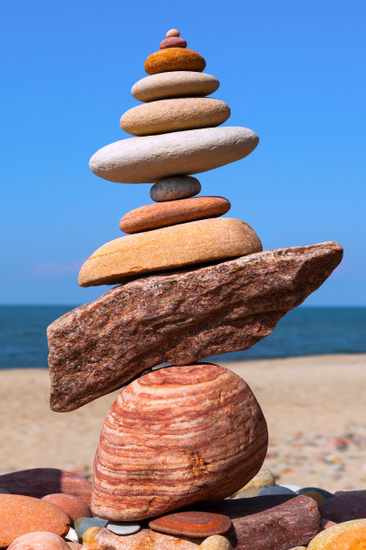 岩石禅宗金字塔的彩色鹅卵石在蓝天的背景图片下载