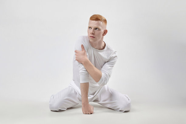 红发男舞者展示舞蹈的舞蹈元素。在摄影棚拍摄白底照片图片下载