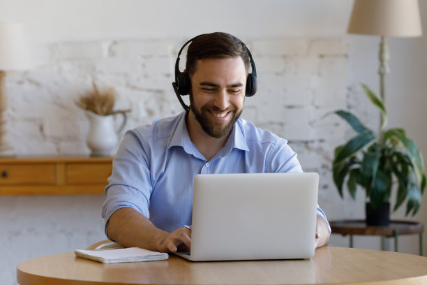 男士戴上耳机进行电子学习，参加商务虚拟会议图片下载