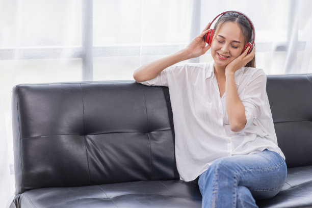 年轻美丽的亚洲女性女孩在休闲穿着放松和听音乐耳机和室内工作图片下载