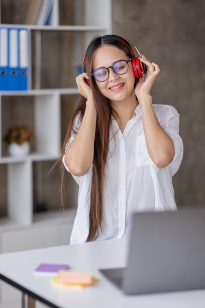 年轻美丽的亚洲女性女孩在休闲穿着放松和听音乐耳机和室内工作图片下载