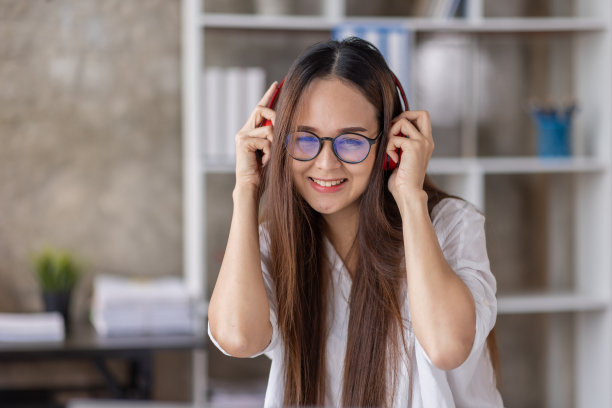 年轻美丽的亚洲女性女孩在休闲穿着放松和听音乐耳机和室内工作图片下载