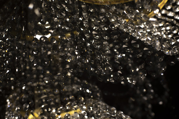 黑暗中的玻璃吊灯。水晶和光线。内部细节。光在房间。图片下载