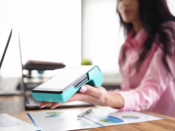 女孩在工作场所持有银行移动设备图片下载