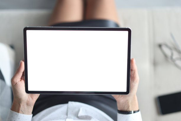 在女性手中用白屏平板。图片下载