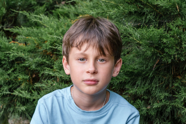 一个9岁的男孩专注地看着镜头图片下载