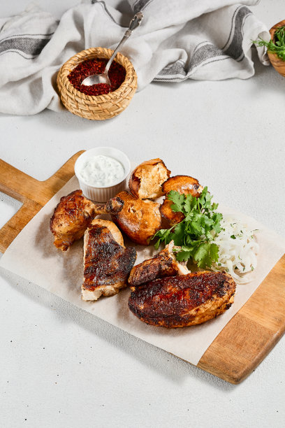 木盘烤鸡配香料和香草。传统的高加索食物——鸡tabaka。烤鸡配面包和酱汁在混凝土背景。图片下载