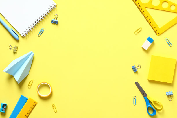 黄色的桌子上平铺着学校文具。回到学校概念。图片下载
