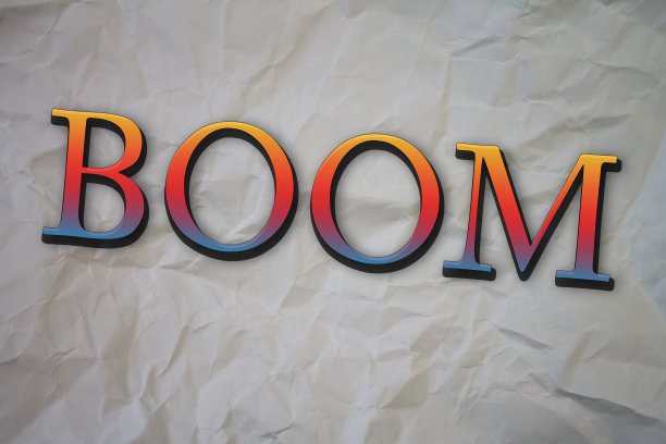 Boom文本撕裂，皱巴巴的白纸彩色背景。图片下载