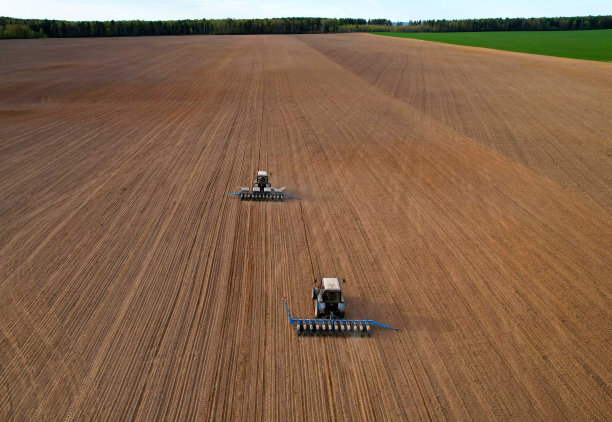 拖拉机在耕地上播种。图片下载