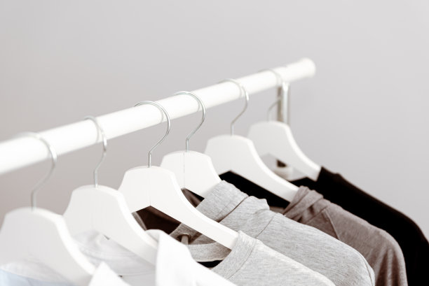 白色衣架上挂着各式各样的棉衣。衣架的特写图片下载