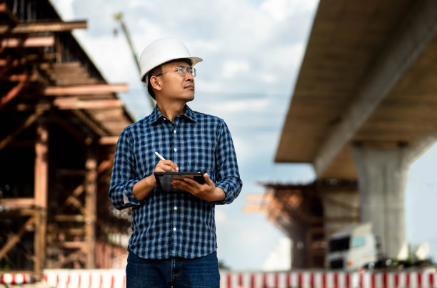 建筑工程师在工厂工作，用电脑检查机械设备。图片下载