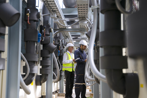 工程师正在建筑物的屋顶上工作。周围高楼林立。图片下载