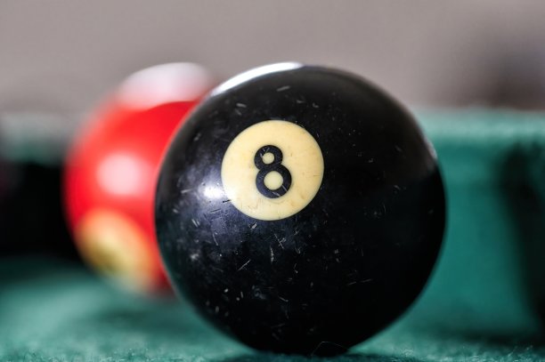 绿色台球桌上带有数字8的黑色台球，附近有其他球。图片下载