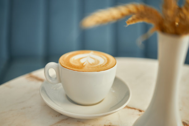 在自助餐厅的大理石桌子上放着带有泡沫的纯白色咖啡图片下载