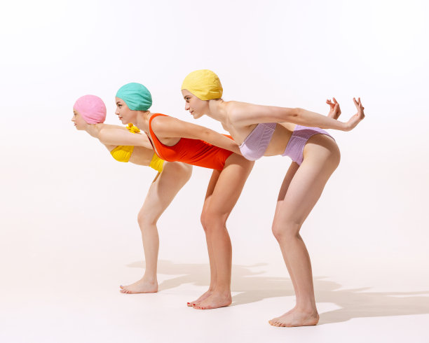 三名年轻女性在复古复古泳衣的肖像孤立在灰色的工作室背景。准备好游泳图片下载