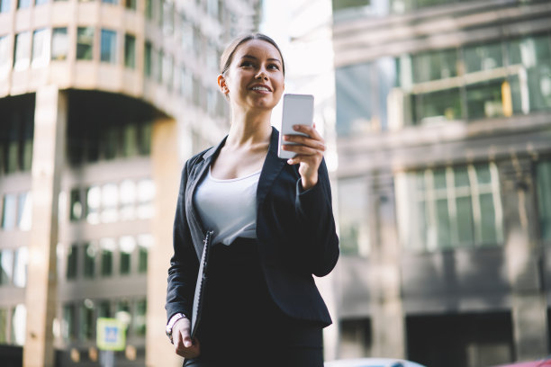 积极的年轻女企业家在街上使用手机图片下载