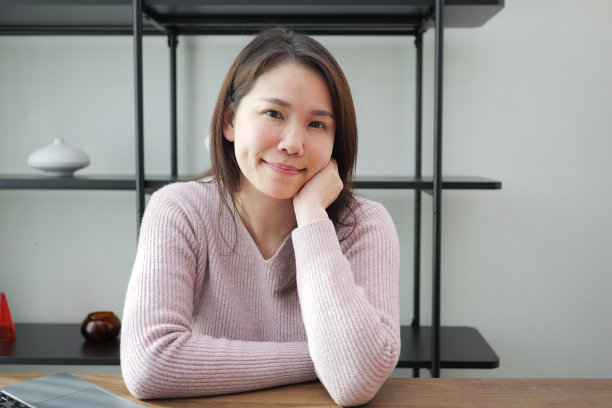 亚洲妇女的肖像微笑和看着相机在家里工作，快乐的工作概念图片下载