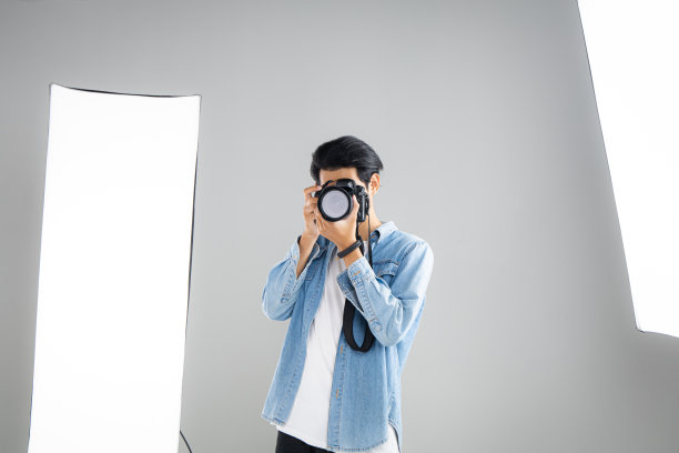 手持专业数码相机的摄影师。图片下载