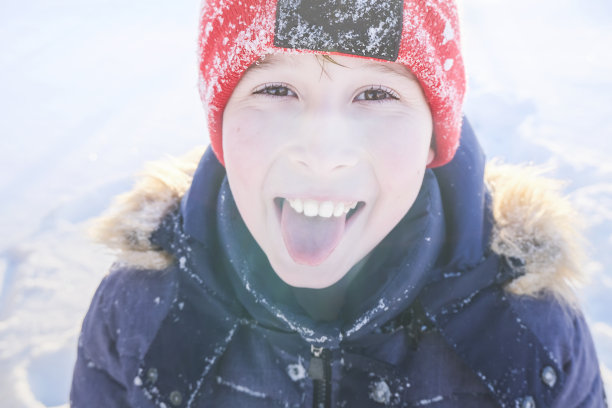 一个孩子在冬日夕阳下的肖像。浅景深的彩色照片。图片下载