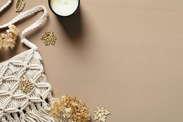 时髦的秋季女性工作空间与流苏包，蜡烛，干花，装饰在棕色的背景。平铺，俯视图，拷贝空间。舒适，舒适，波西米亚风格。图片下载