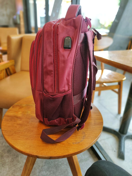 红色的包放在木桌上图片下载