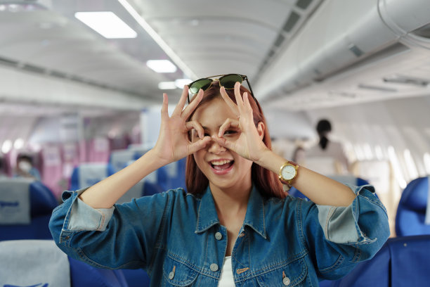 一名亚洲女性在等待经济舱航班时自拍或捕捉回忆的照片。旅游理念，度假，旅游图片下载