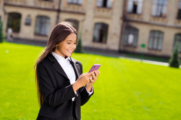 小女生的照片拿着电话看屏幕微笑着穿黑色制服白色衬衫城市城市在户外图片下载