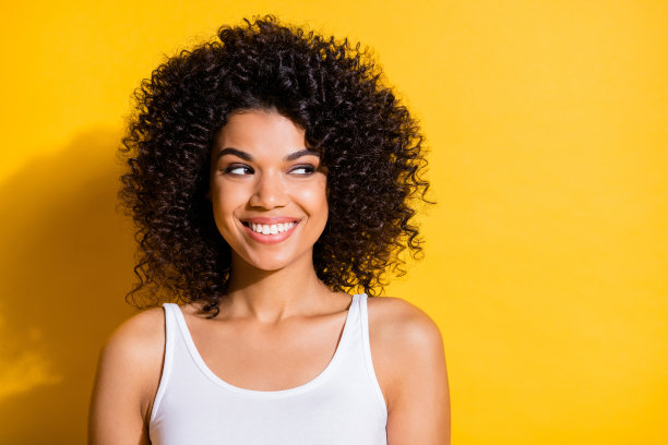 可爱可爱的年轻深色皮肤女士穿白色背心看空空间孤立的黄色背景照片图片下载