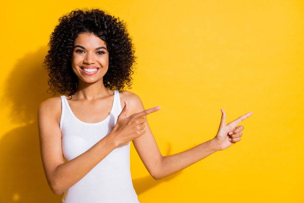 照片相当积极的黑皮肤女士直接手指空的空间命题孤立在黄色的背景色图片下载