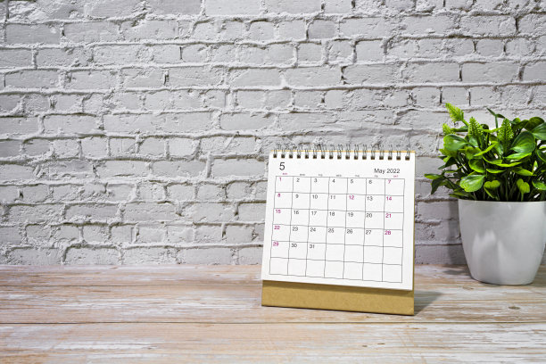 2022年5月白色日历，木桌上有盆栽植物。图片下载