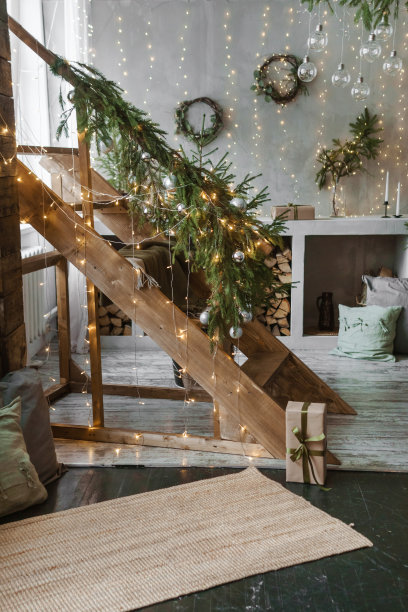 俄罗斯特维尔- 2021年11月10日。家新年的室内。一棵活圣诞树和厨房里的木楼梯。温馨的家庭度假氛围，阁楼设计的房间，日光，绿色的圣诞树用彩灯装饰图片下载