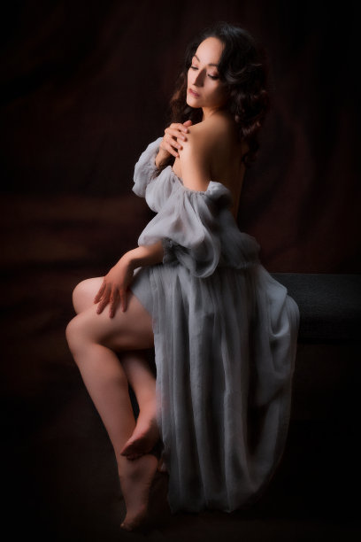 美丽的拉丁女人穿着一件古色古香的衣服，她摆着姿势坐着她很舒服，很低调图片下载