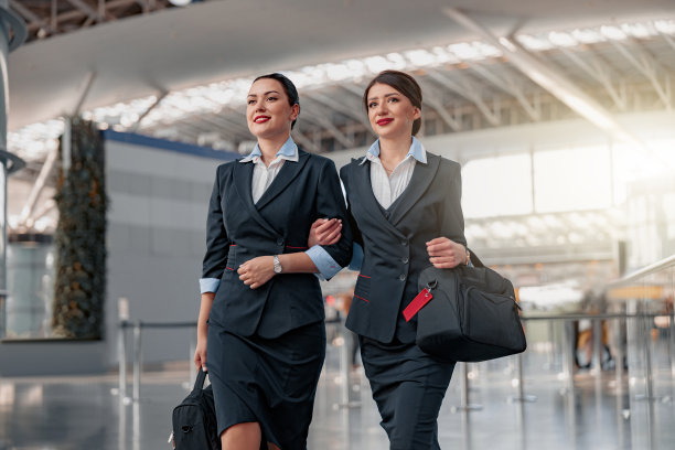 带着行李微笑的漂亮空姐走过航站楼图片下载