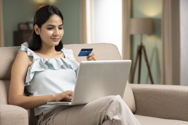 年轻女子在网上购物在家里的笔记本电脑库存照片图片下载