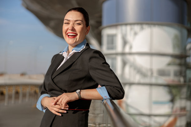 漂亮的女空姐站在候机楼附近笑着图片下载