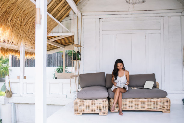 集中的少数民族自由职业者坐在沙发上做项目图片下载