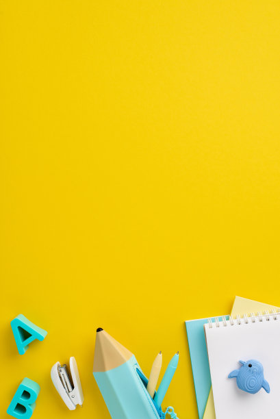 回到学校概念。俯视图垂直照片的学校用品塑料字母笔记本铅笔盒钢笔订书机动物形状的橡皮在孤立的黄色背景与copyspace图片下载