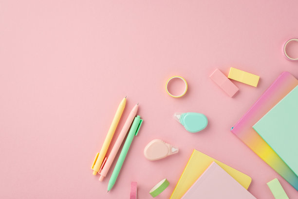 学习用品的概念。顶视图照片的彩色文具笔记本笔圆校正磁带橡皮和胶带上孤立的粉红色背景图片下载