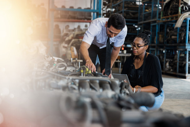 商务男士和女士讨论并看着平板电脑检查工业中的旧汽车零部件图片下载