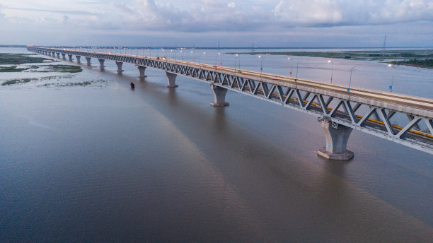 横跨帕德马河在孟加拉国最长的桥与一辆车在桥上在日落天空和云-股票照片图片下载