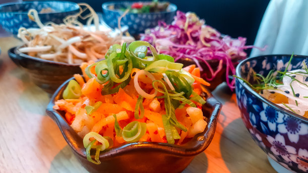 蓝色和白色图案的碗里五颜六色的韩国食物图片下载