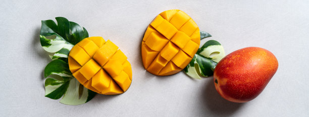 芒果背景设计理念。在灰色的桌子上切好的新鲜芒果丁。图片下载