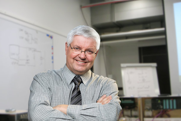 老人微笑着白发苍苍的男人在教育课堂上，老师身旁的黑板和设备图片下载